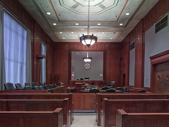 Empty courtroom with wooden benches, judge’s bench, jury box, and American flag visible—where California DUI cases are heard and attorneys dispute breathalyzer results under bright ceiling lights.