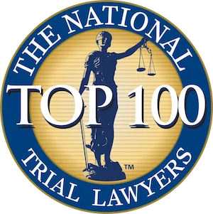 Circular badge with a gold background, blue border, and text reading "The National Trial Lawyers Top 100" surrounding an image of Lady Justice holding scales, recognizing distinguished trial lawyer Dale R. Gomes.