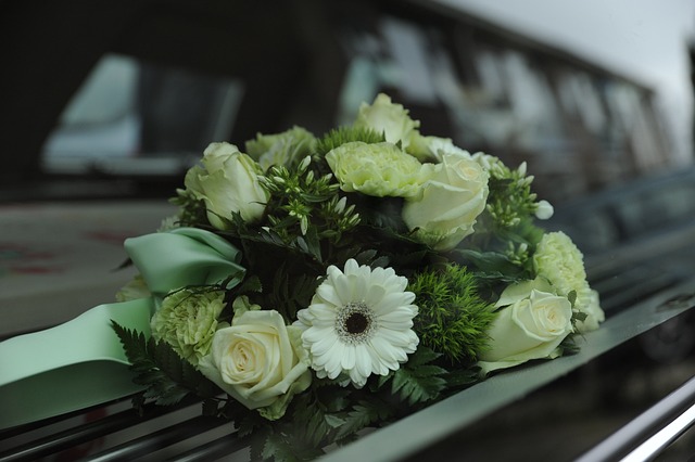 A floral arrangement with white roses, carnations, and greenery rests on the window ledge of a vehicle—serving as a gentle reminder that serious consequences, like jail for third DUI in California, can forever alter moments like these.