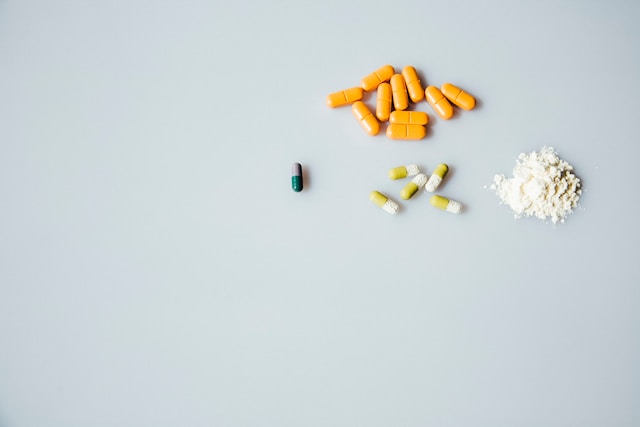 Assorted pills and a pile of white powder are arranged on a plain white surface, highlighting cases that attorneys like Dale R. Gomes, Esq., a National Trial Lawyers Top 100 member, often address.